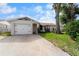 This house boasts a well-maintained front yard and attached garage, showcasing curb appeal and convenience at 10202 Bellhurst Ct, Tampa, FL 33615