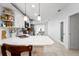 Modern white kitchen featuring sleek countertops, stainless steel appliances, and decorative pantry door at 10202 Bellhurst Ct, Tampa, FL 33615