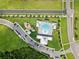 Aerial view of community pool and playground amenities surrounded by lush landscaping and parking at 10580 Gliding Eagle Way, Land O Lakes, FL 34638