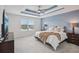 This bedroom features a decorative ceiling, serene blue walls, and a lovely view of the water at 10580 Gliding Eagle Way, Land O Lakes, FL 34638