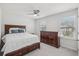 Bedroom with a wooden frame bed, two windows, a dark wood dresser, and neutral colored carpet flooring at 10580 Gliding Eagle Way, Land O Lakes, FL 34638