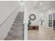 Welcoming entryway with a staircase, stylish mirror, bench seating, and views of the kitchen and office area at 10580 Gliding Eagle Way, Land O Lakes, FL 34638