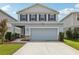 Charming two-story home featuring blue shutters, a two-car garage, and manicured landscaping at 10580 Gliding Eagle Way, Land O Lakes, FL 34638