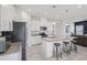 Bright kitchen features white cabinets, granite countertops, stainless steel appliances, and a convenient island with bar stool seating at 10580 Gliding Eagle Way, Land O Lakes, FL 34638