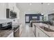 Modern kitchen with stainless steel appliances, granite countertops, and white cabinetry opening up to living space at 10580 Gliding Eagle Way, Land O Lakes, FL 34638