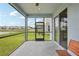 View of the screened-in lanai and backyard featuring a pond and neighboring homes at 10580 Gliding Eagle Way, Land O Lakes, FL 34638