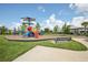 A view of the community playground with colorful equipment and a covered picnic area at 10580 Gliding Eagle Way, Land O Lakes, FL 34638