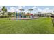 View of the community playground with colorful equipment and surrounding green space at 10580 Gliding Eagle Way, Land O Lakes, FL 34638