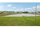 Scenic view of a community pond surrounded by lush green grass and residential properties at 10580 Gliding Eagle Way, Land O Lakes, FL 34638