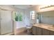Bright bathroom featuring a soaking tub, glass shower, double sink vanity with modern fixtures and an outside view at 10605 Marsanne Pl, Riverview, FL 33578