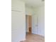 Clean bedroom with wood-look flooring, bright white walls, and a closet with an entrance to another bedroom at 10605 Marsanne Pl, Riverview, FL 33578