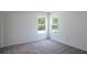 Bedroom featuring two windows, neutral colored walls, neutral carpet, and ample natural light at 10605 Marsanne Pl, Riverview, FL 33578