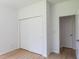 Simple bedroom features a closet, light-colored walls, vinyl floors, and a bright white interior door at 10605 Marsanne Pl, Riverview, FL 33578