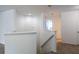 Hallway with neutral-colored carpet and stairs leading down, showcasing the open design at 10605 Marsanne Pl, Riverview, FL 33578