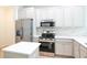 The modern kitchen features stainless steel appliances, stone countertops, and ample storage space at 10605 Marsanne Pl, Riverview, FL 33578