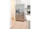 Stainless steel refrigerator with water dispenser complements neutral cabinetry and tiled floor in the bright kitchen at 10605 Marsanne Pl, Riverview, FL 33578