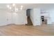 Spacious living area leads to the staircase and the kitchen with white cabinetry and countertops at 10605 Marsanne Pl, Riverview, FL 33578