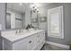 Renovated bathroom includes a double vanity, neutral paint, updated lighting and a window with plantation shutters at 1117 S Florida Ave, Tarpon Springs, FL 34689