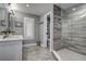 Updated bathroom features a glass enclosed shower, gray tiling and white countertops and cabinets at 1117 S Florida Ave, Tarpon Springs, FL 34689