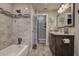 Charming bathroom offers a shower/tub combo, granite countertops, dark wood cabinets and modern fixtures at 1117 S Florida Ave, Tarpon Springs, FL 34689