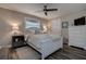 Inviting bedroom features wood look tile floors, neutral paint, updated lighting and a comfortable queen bed at 1117 S Florida Ave, Tarpon Springs, FL 34689