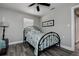 Cozy bedroom featuring a wrought iron bed frame, wood-look tile floors, and ceiling fan at 1117 S Florida Ave, Tarpon Springs, FL 34689