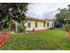 Well-maintained exterior of a one-story home with manicured lawn and privacy landscaping at 1117 S Florida Ave, Tarpon Springs, FL 34689