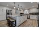 Kitchen island with cooktop, white cabinetry, granite countertops, and stainless refrigerator at 1117 S Florida Ave, Tarpon Springs, FL 34689