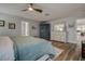 Stylish main bedroom features light blue walls, wood look tile floors, and bright white furniture with beachy decor at 1117 S Florida Ave, Tarpon Springs, FL 34689