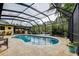 Inviting pool area with screened enclosure and deck, set amidst a backdrop of lush landscaping at 1117 S Florida Ave, Tarpon Springs, FL 34689