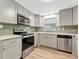 Modern kitchen with stainless steel appliances, grey cabinetry and light wood flooring at 1135 17Th Sw Ave, Largo, FL 33778