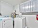Clean laundry room with washer, dryer, water heater and storage cabinets at 1135 17Th Sw Ave, Largo, FL 33778