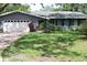 Charming single-story home with a brick driveway, manicured lawn, and attached two-car garage at 12794 Palm Dr, Largo, FL 33774