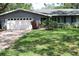 Charming single-story home with a brick driveway, manicured lawn, and attached two-car garage at 12794 Palm Dr, Largo, FL 33774