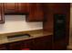 Kitchen with granite countertops, wood cabinets, and built-in cooktop, and black oven and microwave combination at 12794 Palm Dr, Largo, FL 33774
