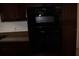 A built-in black oven and microwave combo set in the kitchen area with brown cabinets and neutral wall color at 12794 Palm Dr, Largo, FL 33774