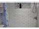 A pristine white tiled shower featuring a sleek showerhead, a handy shelf, and a stylish curtain at 12794 Palm Dr, Largo, FL 33774