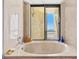 Bright bathroom featuring a soaking tub with a view and beige marble surround at 1290 Gulf Blvd # 702, Clearwater Beach, FL 33767