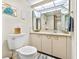Well-lit bathroom with a vanity, toilet and a framed mirror at 1290 Gulf Blvd # 702, Clearwater Beach, FL 33767