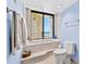 Bathroom featuring a large soaking tub, toilet, towels and view of the ocean at 1290 Gulf Blvd # 702, Clearwater Beach, FL 33767