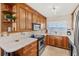 Well-lit kitchen featuring wood cabinetry, stainless steel appliances, and an open layout, enhancing functionality and style at 1290 Gulf Blvd # 702, Clearwater Beach, FL 33767