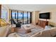Cozy living room with sliding glass doors, a comfortable sofa, a TV and a scenic balcony offering a relaxing space at 1290 Gulf Blvd # 702, Clearwater Beach, FL 33767