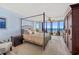 A spacious main bedroom with a canopy bed, large windows and balcony overlooking the ocean at 1290 Gulf Blvd # 702, Clearwater Beach, FL 33767