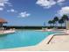 Sparkling community pool with lounge chairs, tables and beach views under a sunny sky at 1290 Gulf Blvd # 702, Clearwater Beach, FL 33767