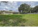 Expansive backyard featuring a well-maintained lawn, mature trees, and a charming screened patio for outdoor enjoyment at 14047 Briardale Ln, Tampa, FL 33618