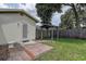 Backyard featuring a paved walkway, small gazebo, door access to the property and green landscaping at 14047 Briardale Ln, Tampa, FL 33618