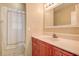 Bright bathroom features a cherry wood vanity, a sink, a mirror and a shower with a white shower curtain at 14047 Briardale Ln, Tampa, FL 33618
