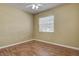 This bedroom features a ceiling fan, wood flooring, and a window for natural light at 14047 Briardale Ln, Tampa, FL 33618