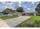 Charming single-story home with a brick facade, well-manicured lawn and curved driveway at 14047 Briardale Ln, Tampa, FL 33618