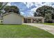 Charming home featuring a driveway, grassy front lawn, and a beautiful front door and shutter details at 14047 Briardale Ln, Tampa, FL 33618